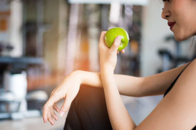 mujer-deportes-sentado-comiendo-manzana-verde-gimnasio-entrenamiento-fitness_10307-113.jpg